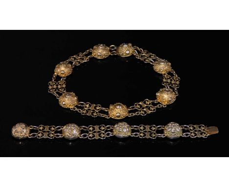 A Victorian silver gilt matched necklace and bracelet, with the necklace composed of a series of decorated domed links betwee