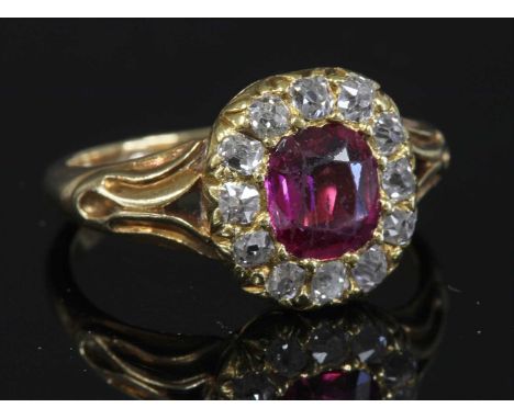 A late Victorian ruby and diamond cushion-shaped cluster ring, with a central cushion cut ruby, claw set to the centre. A bor