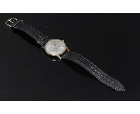 A gentlemen's 9ct Garrard automatic strap watch, c.1970,with a circular case, 33mm diameter. A silvered dial with raised gilt