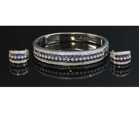 A white gold sapphire and diamond hinged bangle and earring suite,by Colombian Emeralds International, the graduated hinged b