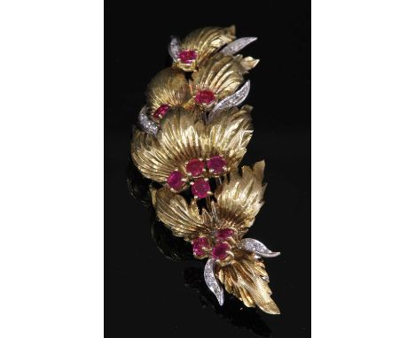 An 18ct yellow and white gold ruby and diamond spray brooch, c.1960,of arched curved form with rows of textured incised leave