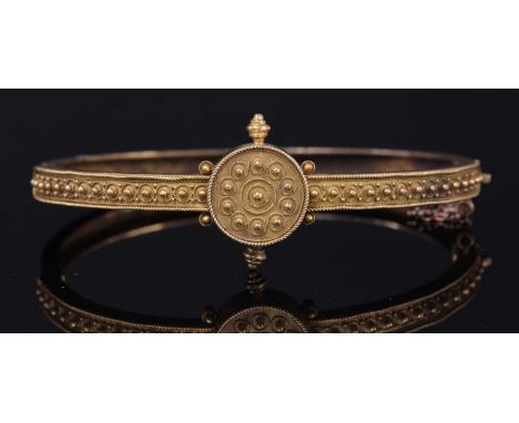 A Victorian Archaeological Revival Etruscan-style gold hinged bangle, c.1870, a flat section oval-shaped hinged bangle, with 