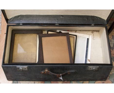 An early 20th Century leather trunk containing a collection of various picture frames.