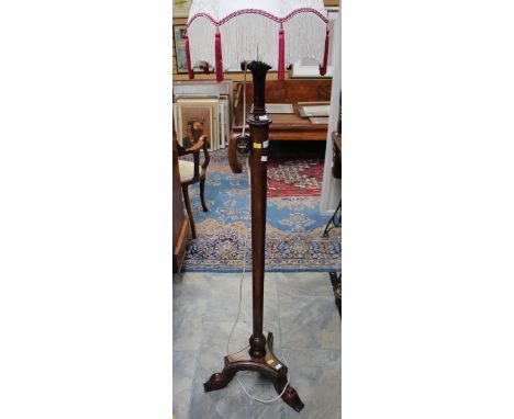 A late 20th Century beech standard lamp, the cream shade raised on an Empire style base, height 173cm. 