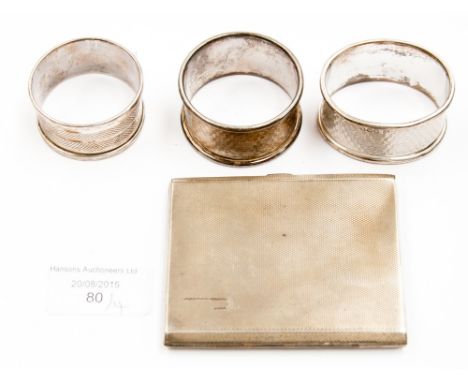 A silver cigarette case, engine turned, together with three silver napkin rings