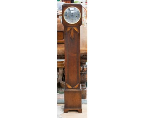A George V Art Deco oak cased Grand Daughter clock, circa 1925, with an eight day movement, the glazed door opening to reveal