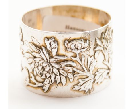 A Chinese silver napkin ring, Hung Chong and Co, with cast and chased floral and foliate decoration, cartouche engraved with 