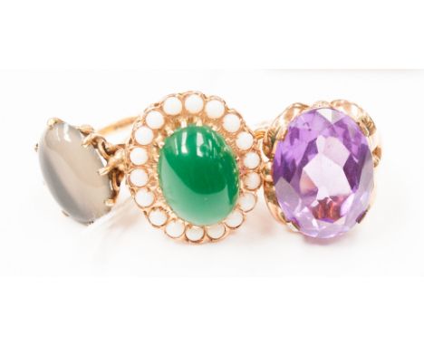 An opal and green stone cluster ring, an agate ring and another.