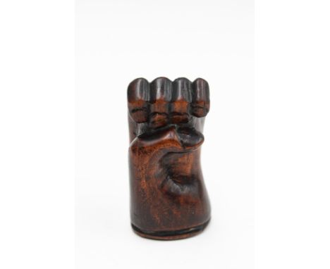 A 19th Century stained wood snuff box, carved in the form of a hand clenched fist 