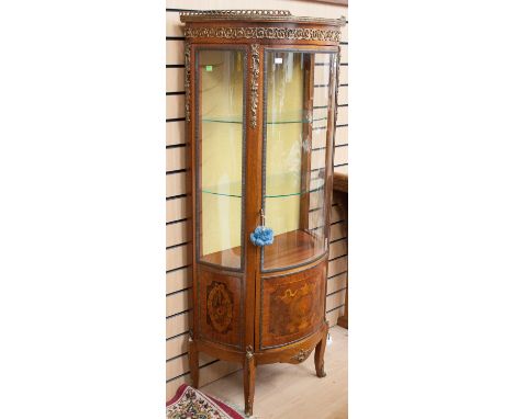 A French style bow fronted display cabinet with a shape panelled glazed door, with marquetry inlaid panel, raised on slender 