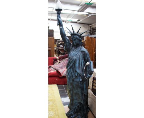 A statute of Liberty figural standard lamp complete with a frosted glass shade.
