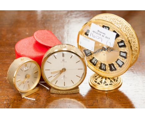 A Jaeger brass cased mantle clock; together with a further Jaeger bedside clock and one other, one in a red case (3) 