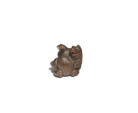 KOKEI OF KUWANA, ISE PROVINCEA Wood Netsuke of a Tanuki (Japanese Raccoon Dog) Edo period (1615-1868), 19th centurySeated in 