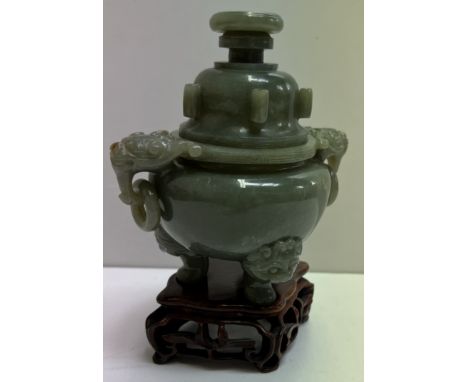 A Chinese green hardstone / jade vase and cover with lion and ring handles on three feet and a base  