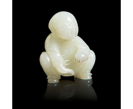 PALE CELADON JADE CARVING OF A SQUATTED BOY QING DYNASTY, 18TH CENTURY carved in round as a boy in squatting position, his le