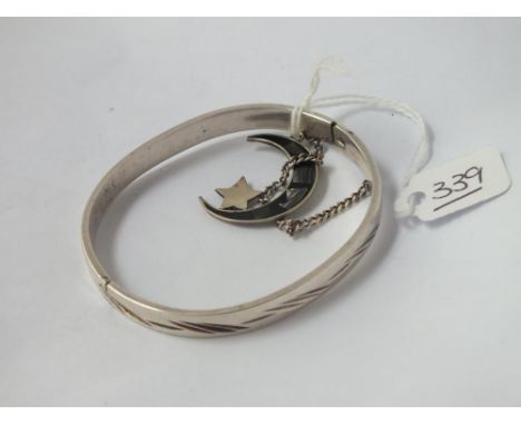 A white metal bangle together with a silver crescent pendant 