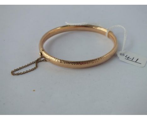 A HAMMERED EFFECT BANGLE IN 15CT GOLD - 10.1GMS