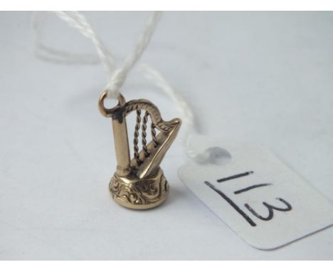 A small harp charm set in gold 