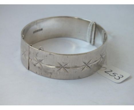 A wide silver engraved bangle