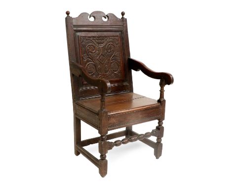 A Joined Oak Wainscot Armchair, late 17th/early 18th century, with turned finials and scrolled top rail above a fielded back 