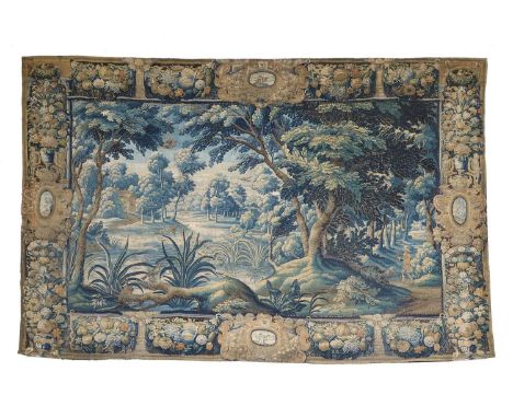 Flemish Verdure Tapestry, circa 17th centuryWoven in silks and wool depicting a rural wooded landscape and a hunting lodge be
