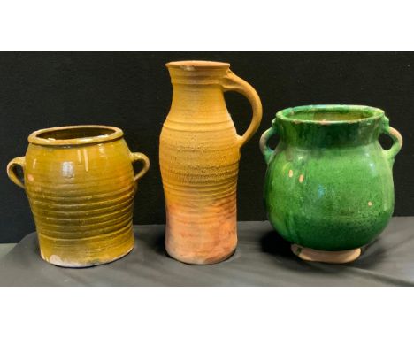An Archaic style green glazed terracotta vessel, two handles, 33cm high;  another brown ribbed, 29cm high;  a banded pitcher 