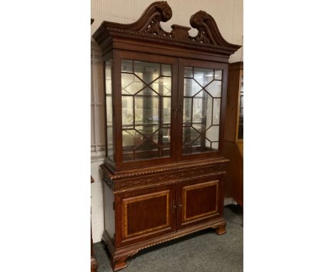 A Georgian style, reproduction, bookcase cabinet, carved scroll cresting and cornice, pair of astral-glazed doors enclosing t