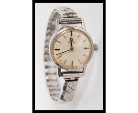 A vintage 1960s Omega wrist watch having a silvered dial with baton numerals and faceted hands. Omega winder present and set 
