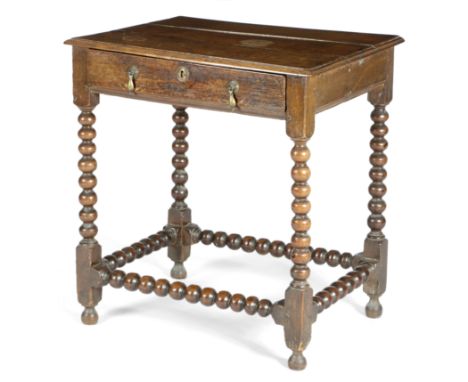 A WILLIAM AND MARY OAK SIDE TABLE C.1690 the boarded top with a moulded edge, above a frieze drawer, on bobbin turned legs un