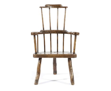 A PRIMITIVE ELM AND ASH WINDSOR STYLE ARMCHAIR POSSIBLY WELSH, LATE 18TH / EARLY 19TH CENTURY the stylised comb top rail abov