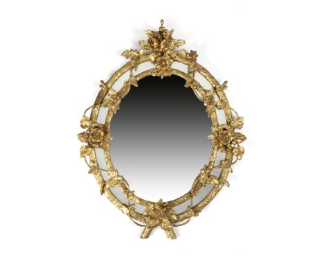 A GILT COMPOSITION WALL MIRROR SECOND HALF 19TH CENTURY the oval plate within a Rococo frame, carved with scrolling leaves an