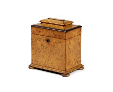 A GEORGE IV BURR ELM TEA CADDY C.1825 of sarcophagus shape, the interior with twin divisions and with a printed paper label, 