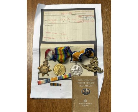 Trio of WWI medals named to 5977 DVR. C. Motley R. A, together with cap badge and French dictionary.