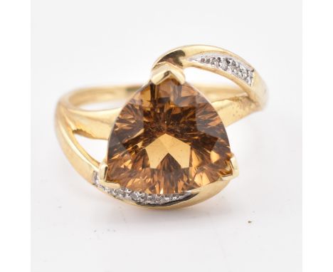 A hallmarked 9ct gold cognac quartz and diamond ring. The 9ct yellow gold ring set with a central trilliant cut cognac quartz