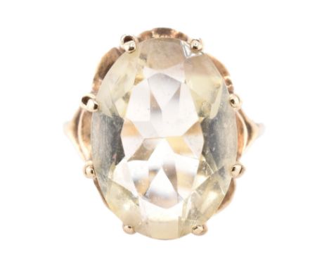 A hallmarked 9ct gold and citrine cocktail ring. The 9ct yellow gold ring having a single oval cut citrine set in a scalloped