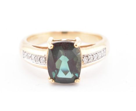 A hallmarked 9ct gold, colour change andesine and diamond ring. The 9ct yellow gold ring having a central antique cut colour 