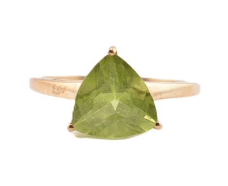 A hallmarked 9ct gold and peridot ring. The ring set with a single trilliant cut peridot to tapering shank. Hallmarked for Bi