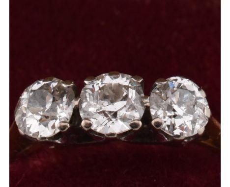 An 18ct gold and diamond three stone ring. The yellow gold ring set with three round brilliant cut diamonds to chenier should