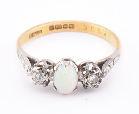 A hallmarked 18ct gold opal and diamond three stone ring. The 18ct yellow gold ring set with a central oval opal cabochon fla
