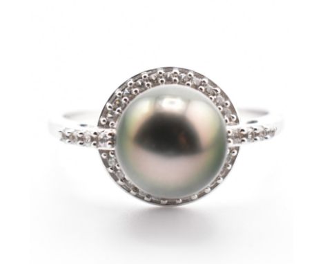 A hallmarked 9ct gold Tahitian pearl and topaz ring. The 9ct white gold ring having a single round Tahitian pearl surrounded 