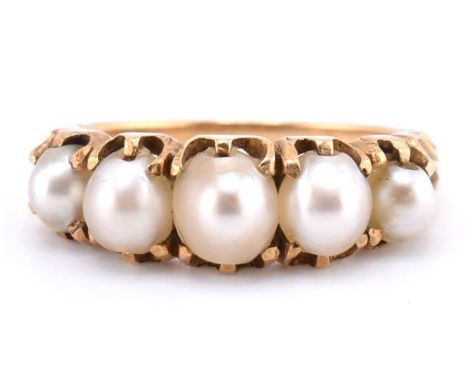 A gold and pearl five stone ring. The gold ring set with five graduating full pearls to decorative scrolling shoulders to tap