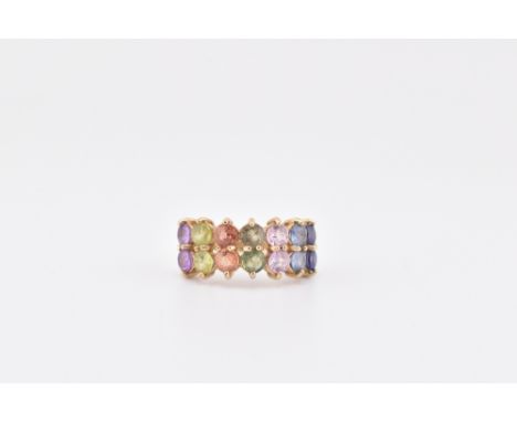 A hallmarked 9ct gold and fancy sapphire ring. The 9ct yellow gold ring set with 14 round cut sapphires set in a colour gradi