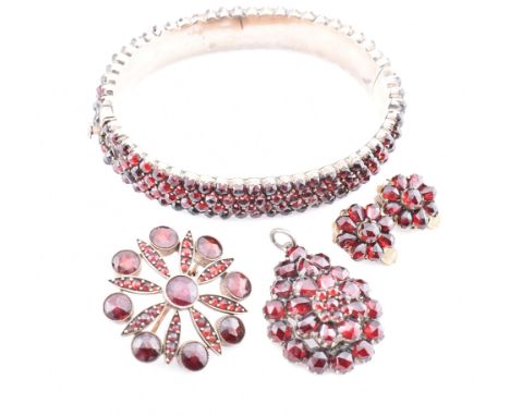A collection of Bohemian garnet jewellery. The lot to include a garnet set hinged bangle with concealed box clasp. A gold and