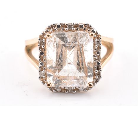 A hallmarked 9ct gold rutile quartz and diamond ring. The 9ct yellow gold ring having a central octagon cut rutile quartz sur