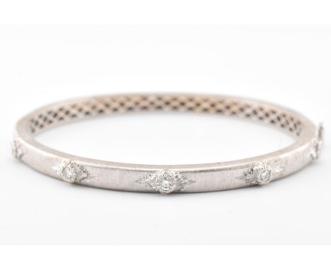 An Italian 18ct white gold and diamond hinged bangle. Stamped Italy &amp; 750, the bangle inset with diamonds, estimated diam
