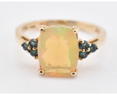 A hallmarked 9ct gold Ethiopian opal and Arusha colour change garnet ring. The 9ct yellow gold ring set with a central four-c