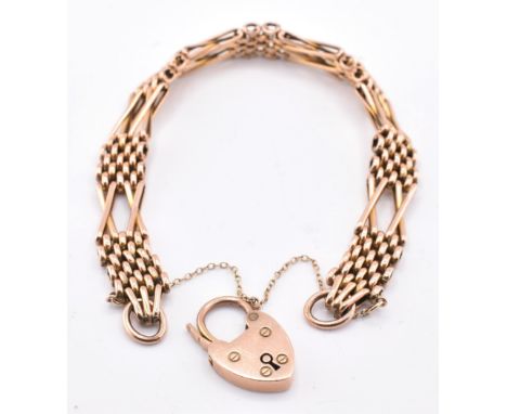 A 9ct rose gold gate link bracelet with heart padlock clasp. The 9ct rose gold gate link bracelet having a heart padlock clas
