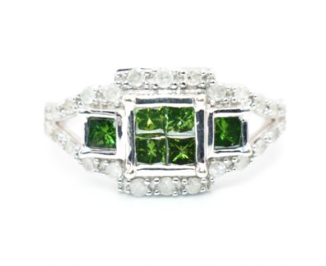 A hallmarked 9ct gold green and white diamond cluster ring. The 9ct white gold ring set with six princess cut diamonds and tw