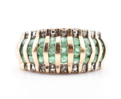 A gold emerald and diamond dome ring. The yellow gold dome ring having nine columns each with three round cut emeralds and tw