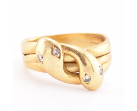 A Victorian hallmarked 18ct gold and diamond snake ring. The 18ct yellow gold ring having two intertwined serpent heads with 